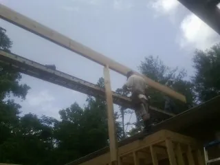 Carpenter setting a ridge beam over a new addition frame — Ice Dam Removal by Roofing Brothers in Cerulean