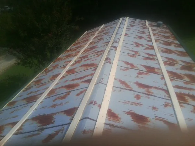 Rusted metal roof panels with new wood purlins before replacement — Storm Damage Roof Repair in Cerulean by Roofing Brothers