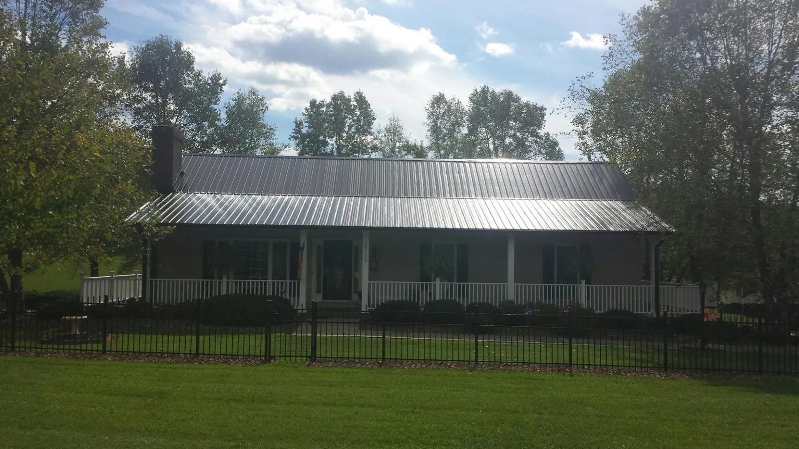 Gray metal roof on a brick ranch with a full width front porch — Gutter Guard Installation work by our crew in Cerulean